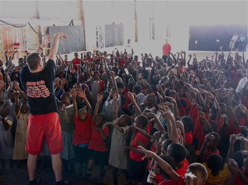 Randy showing the kids how to shoot a basketball